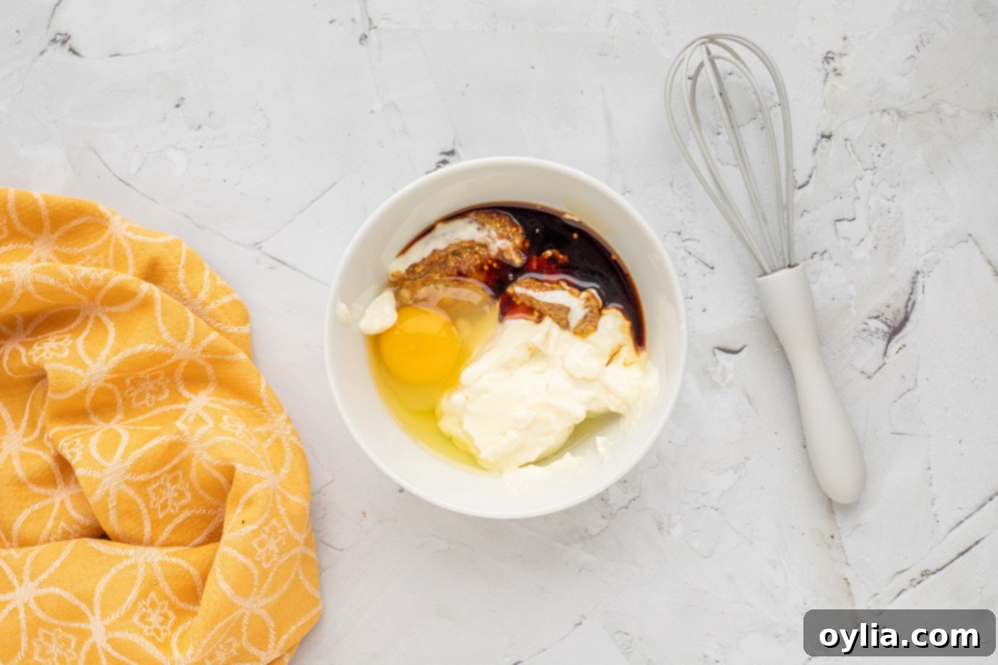 Whisking mayonnaise, soy sauce, ground mustard, egg, and horseradish mayo in a bowl