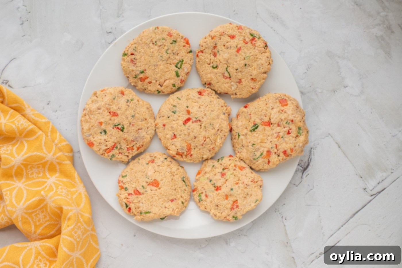 Seven neatly formed salmon cakes on a plate