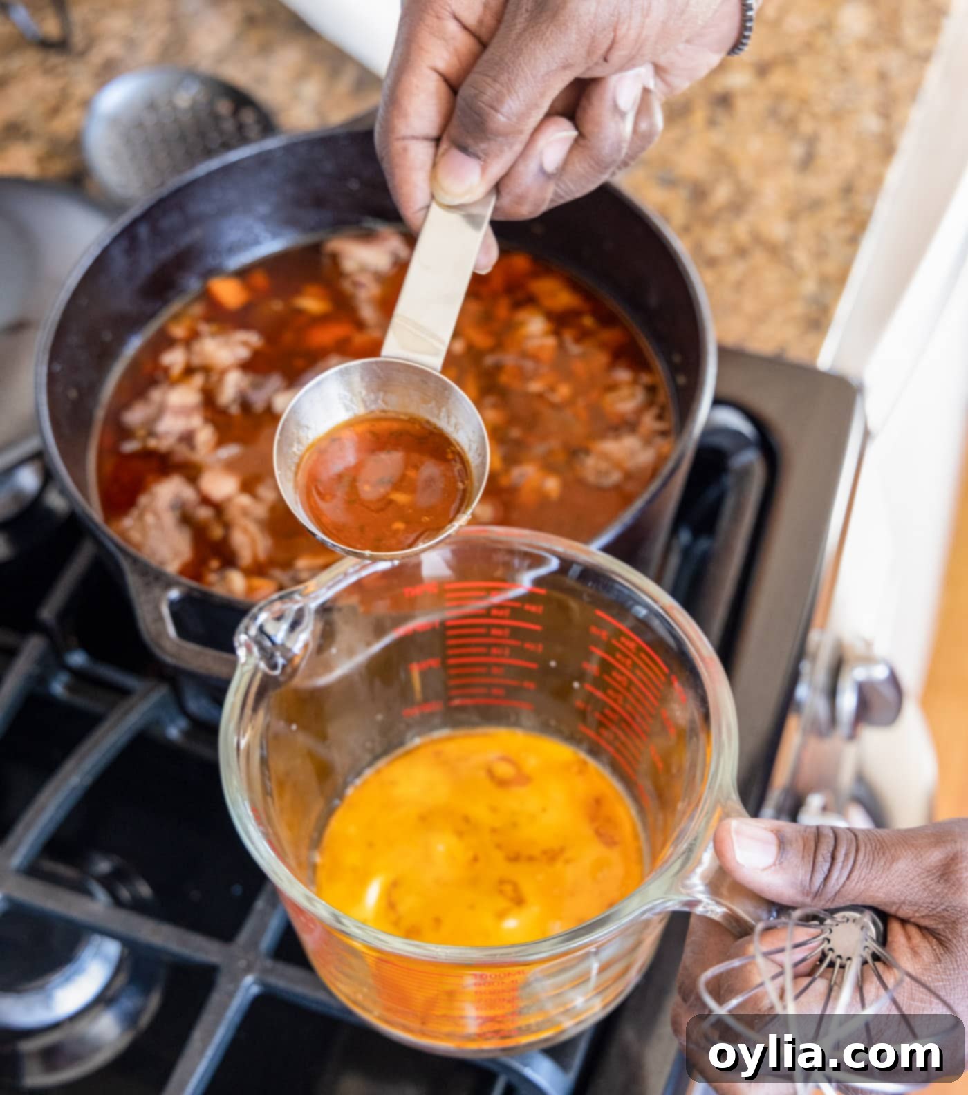 Removing pan juices from Beef Bourguignon into a measuring cup to prepare a thickening agent