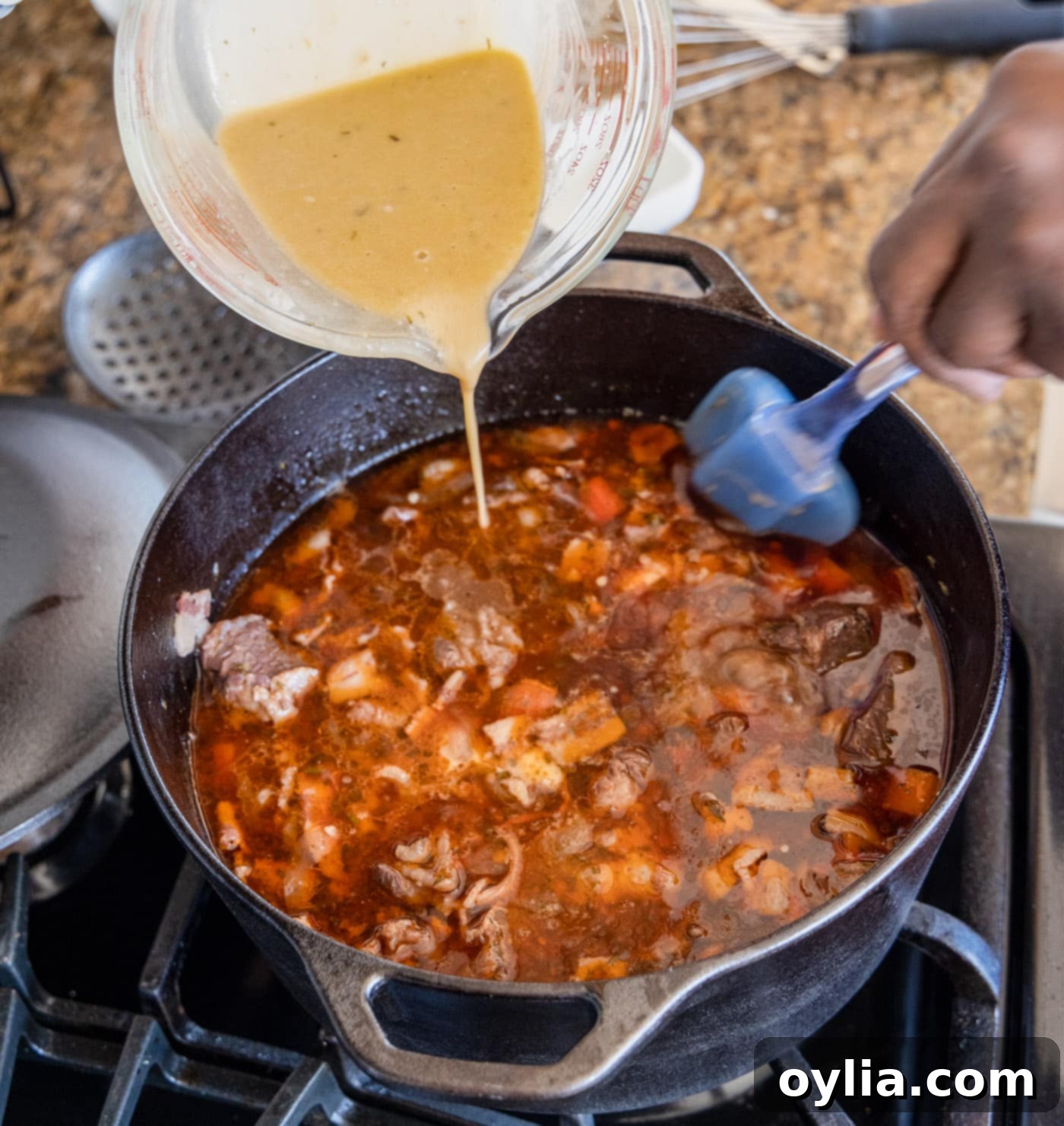 Pouring the flour and pan juice mixture back into the Beef Bourguignon to thicken the sauce