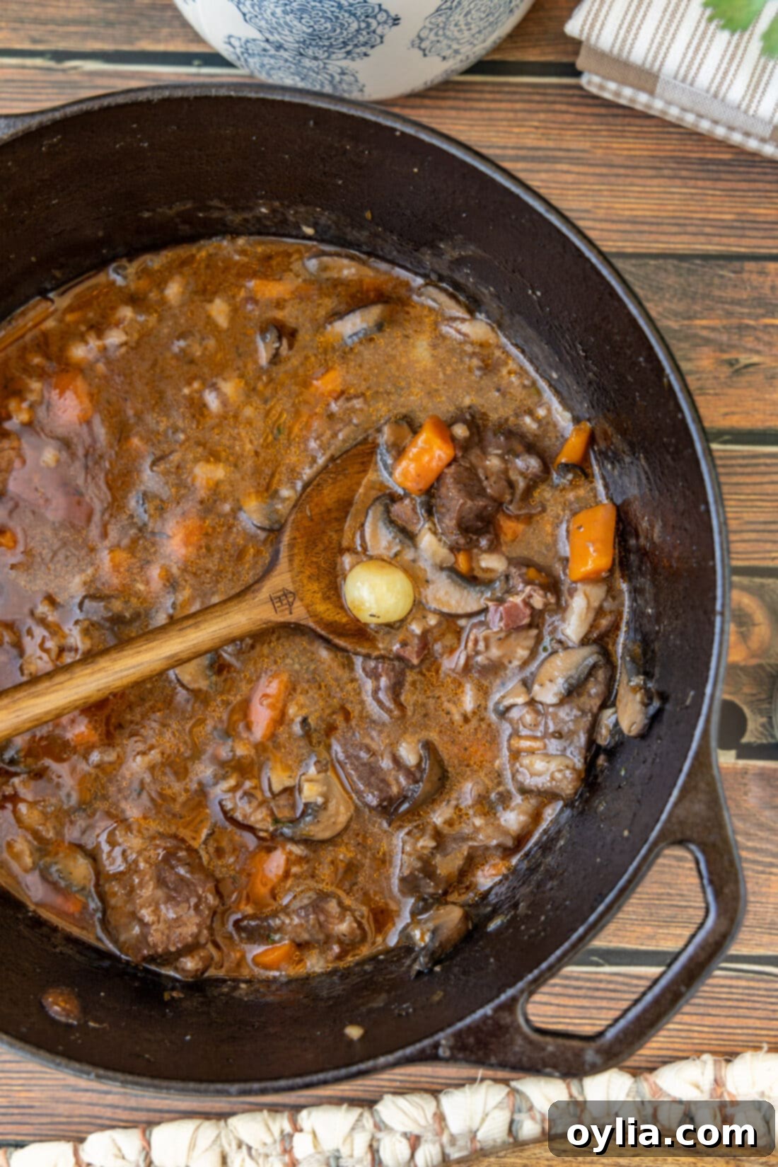 Close-up of Beef Bourguignon in a pot with a wooden spoon, showcasing its rich texture