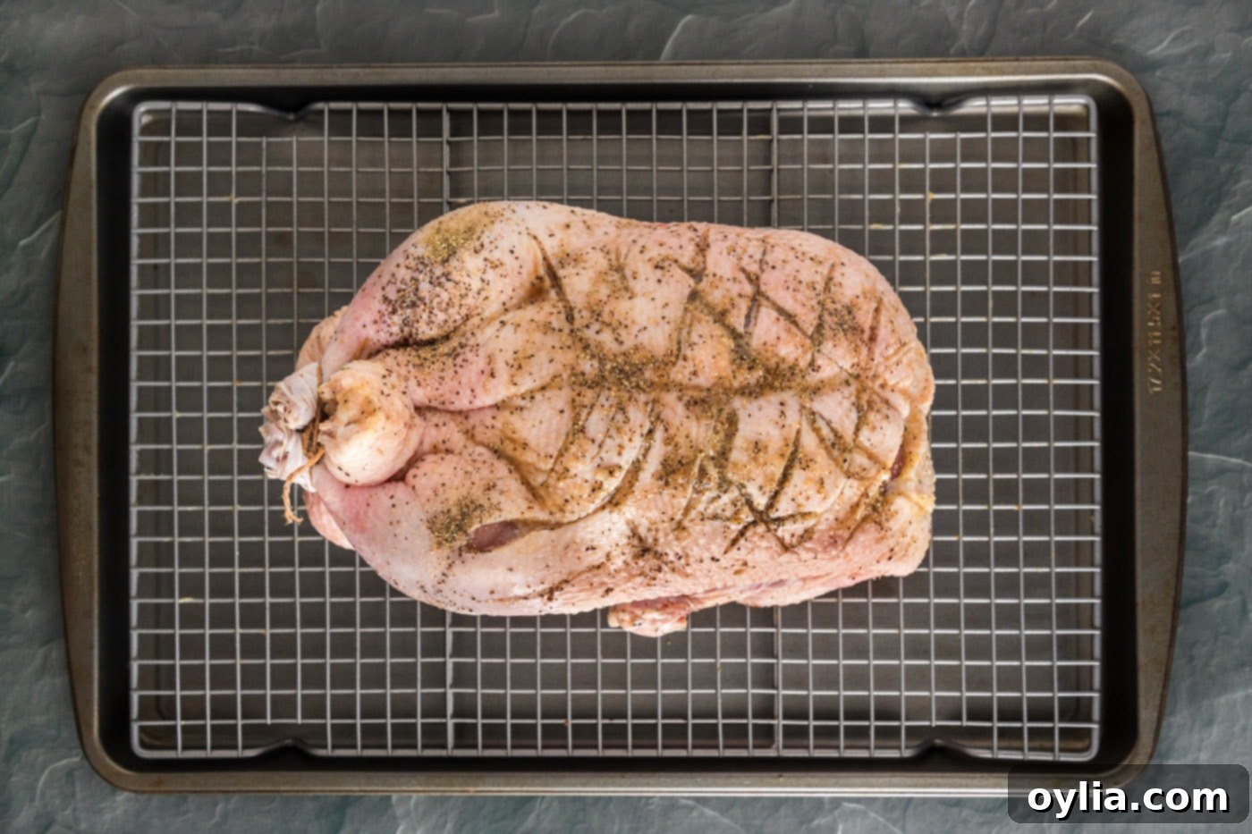 scored whole duck on a baking sheet