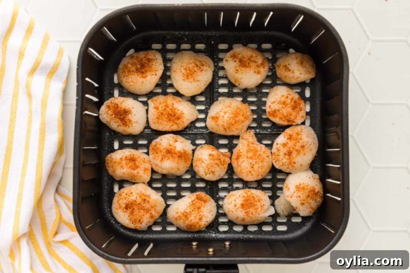 Crispy Air-Fried Scallops 7 Raw seasoned scallops arranged in a single layer in an air fryer basket