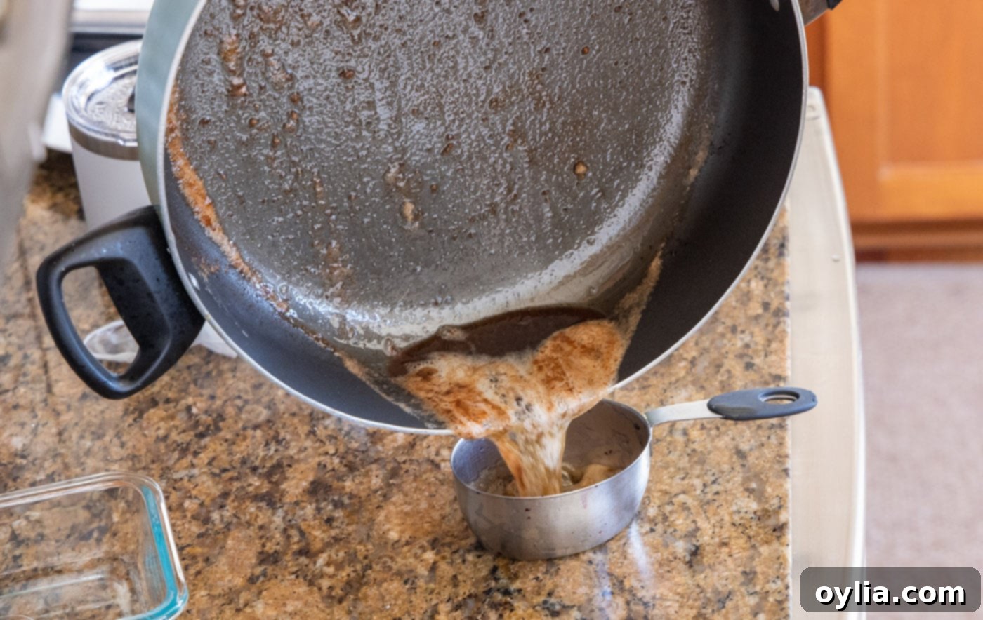 Draining excess oil and butter mixture from the skillet, leaving some fond