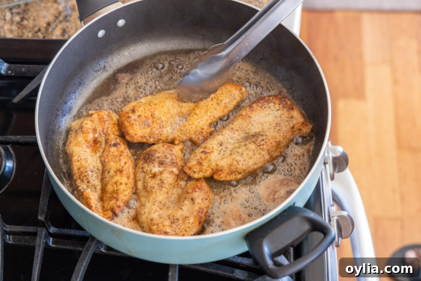 Golden brown seared chicken breasts resting in a skillet
