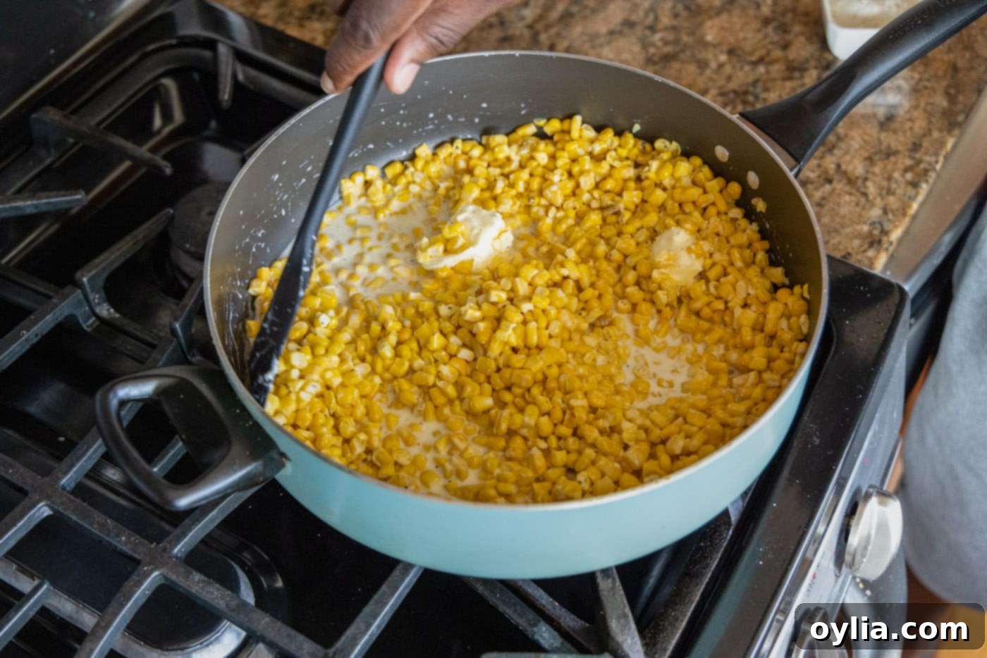 mixing creamed corn in a skillet