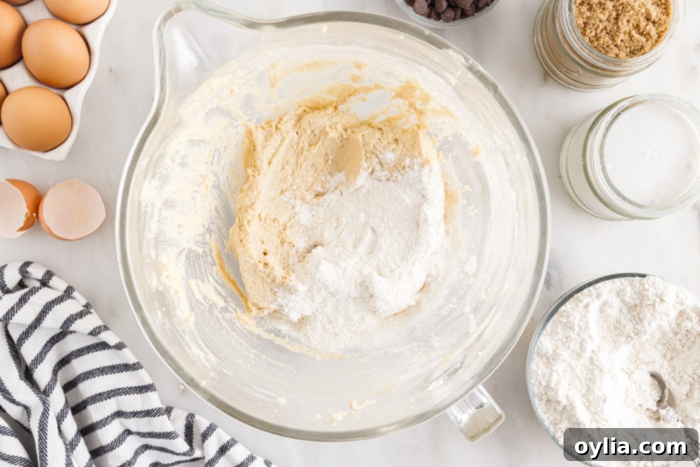 adding flour mixture to butter mixture in a bowl