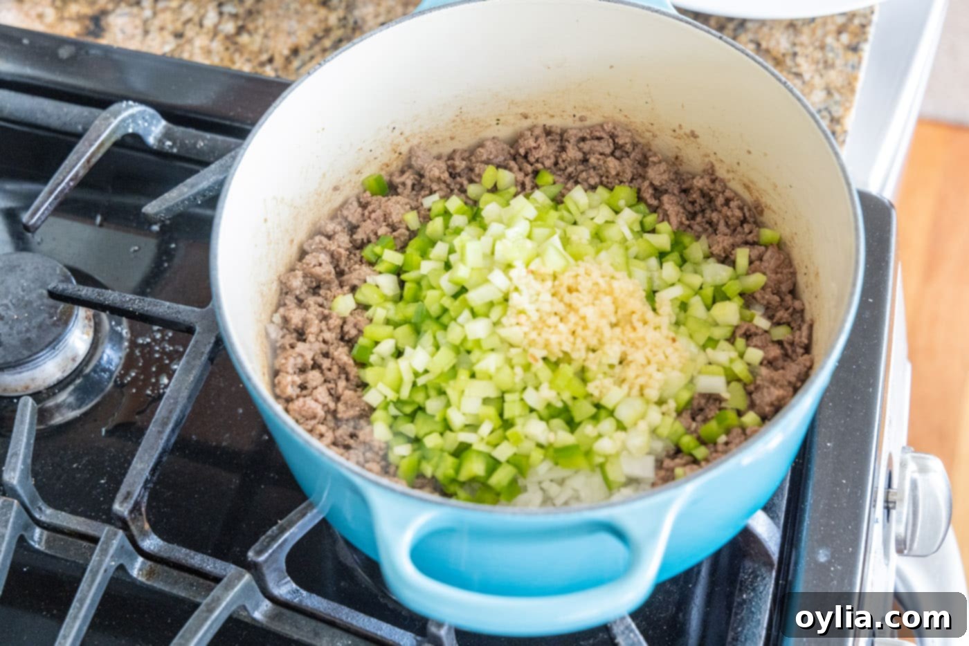 minced garlic added to dutch oven of ground beef, celery, onion, and peppers