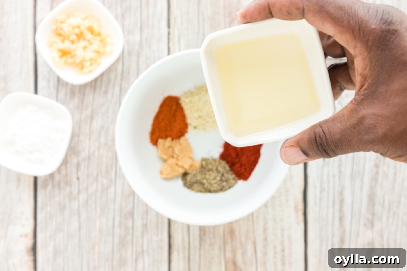 olive oil over bowl of seasonings