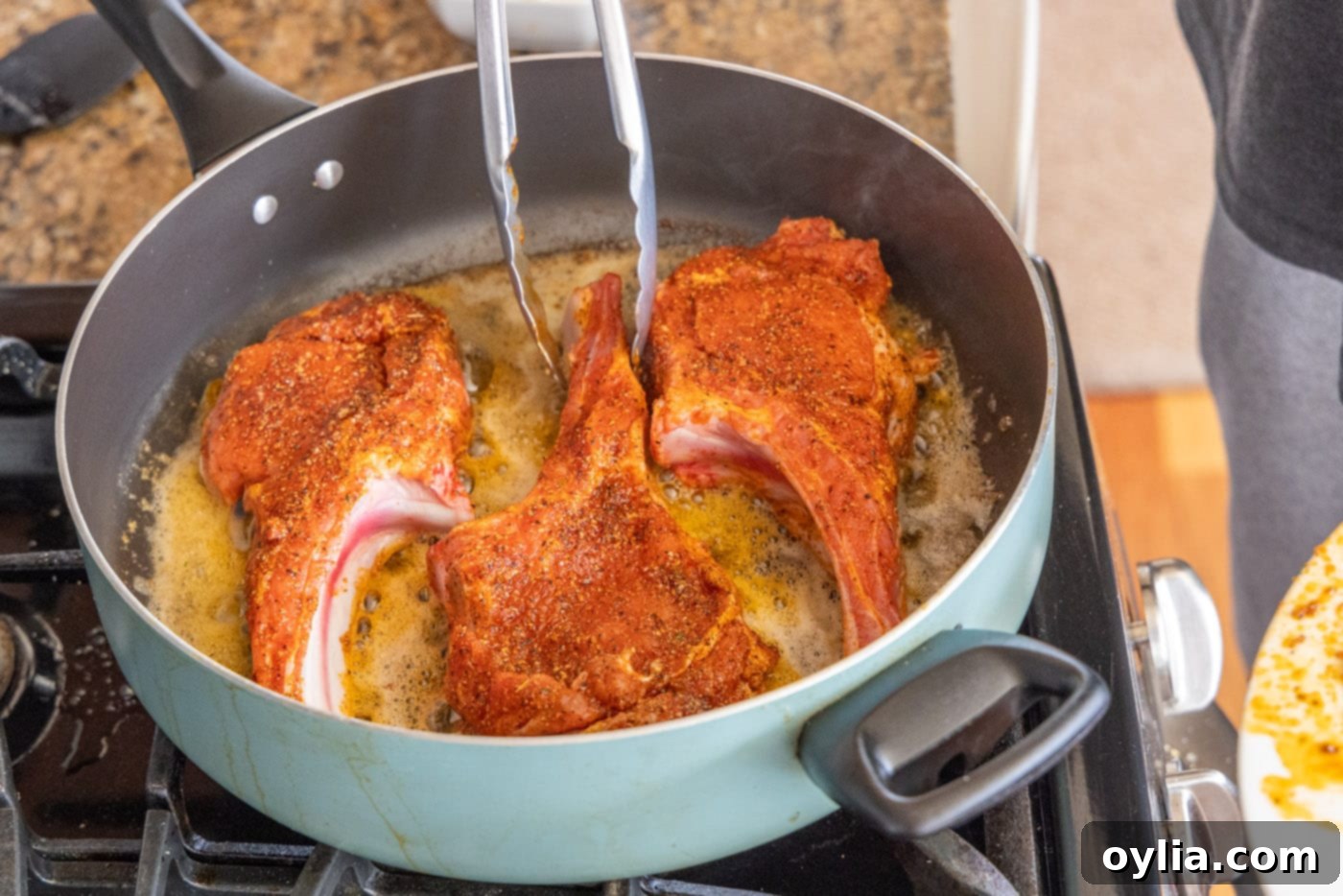 veal chops cooking in skillet