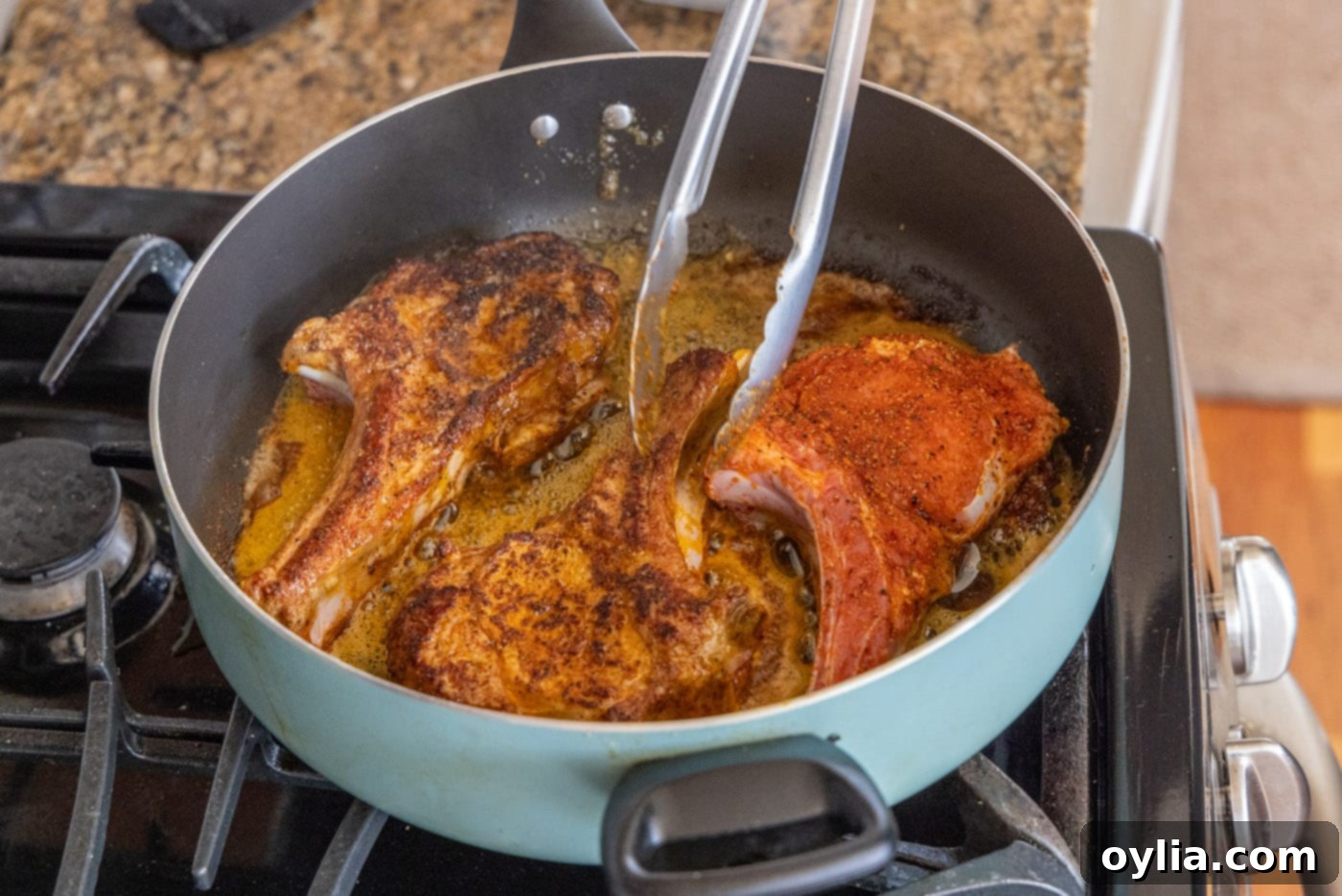 flipping veal chops in a skilet