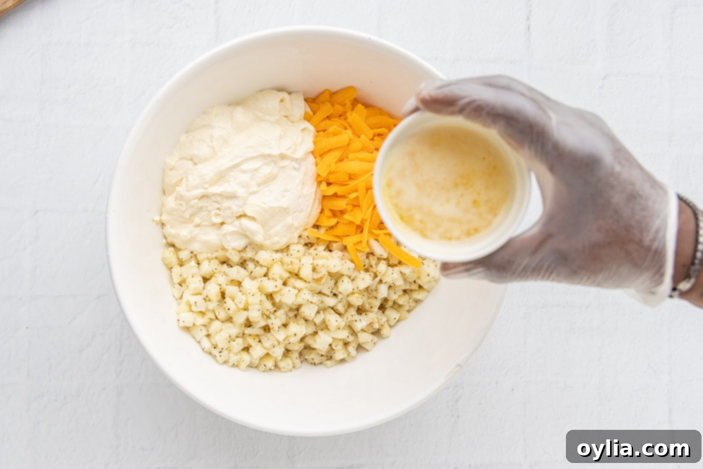 potatoes, cream of chicken mixture, and cheese in a bowl