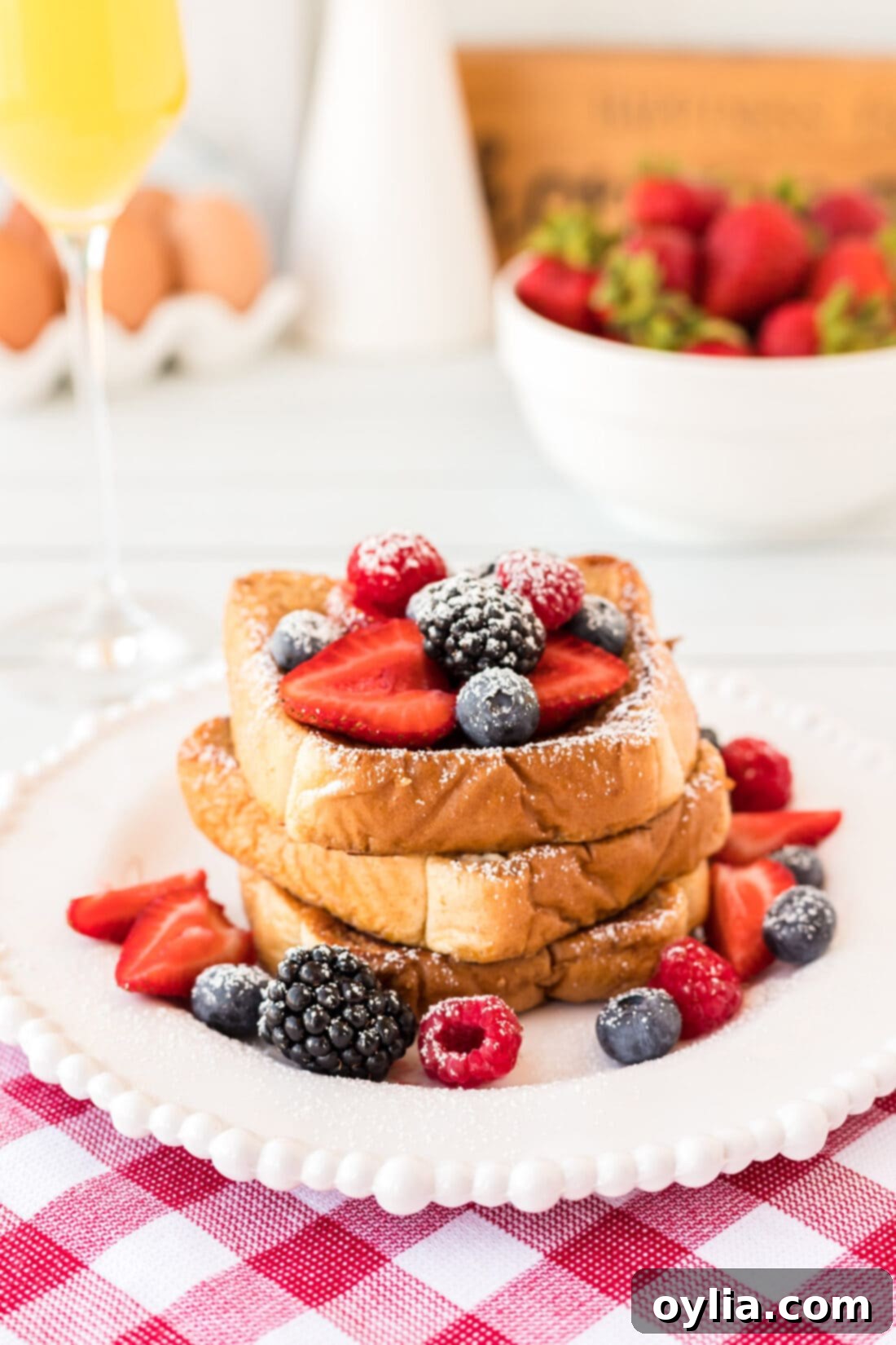 Delicious French Toast topped with fresh berries and powdered sugar on a white plate