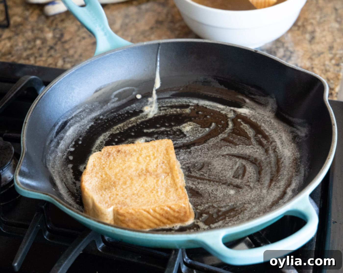 Dipping a slice of thick bread into French toast custard