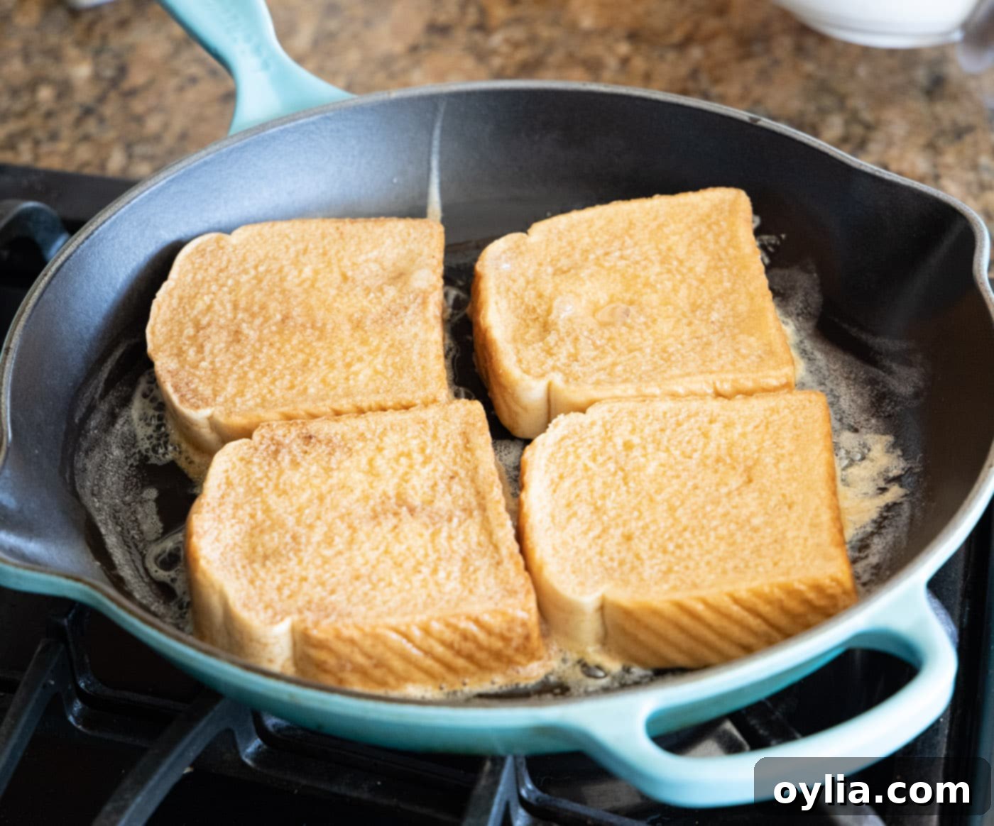 Cooking French toast slices in a hot buttered skillet until golden brown