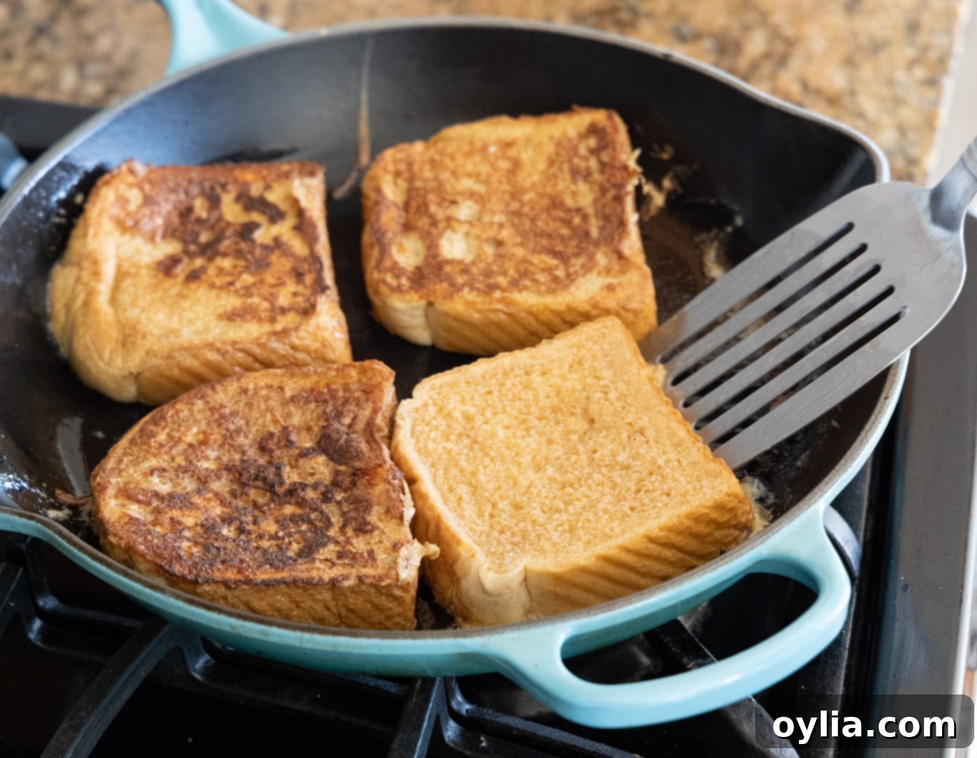 Flipping French toast slices in a skillet to cook the second side
