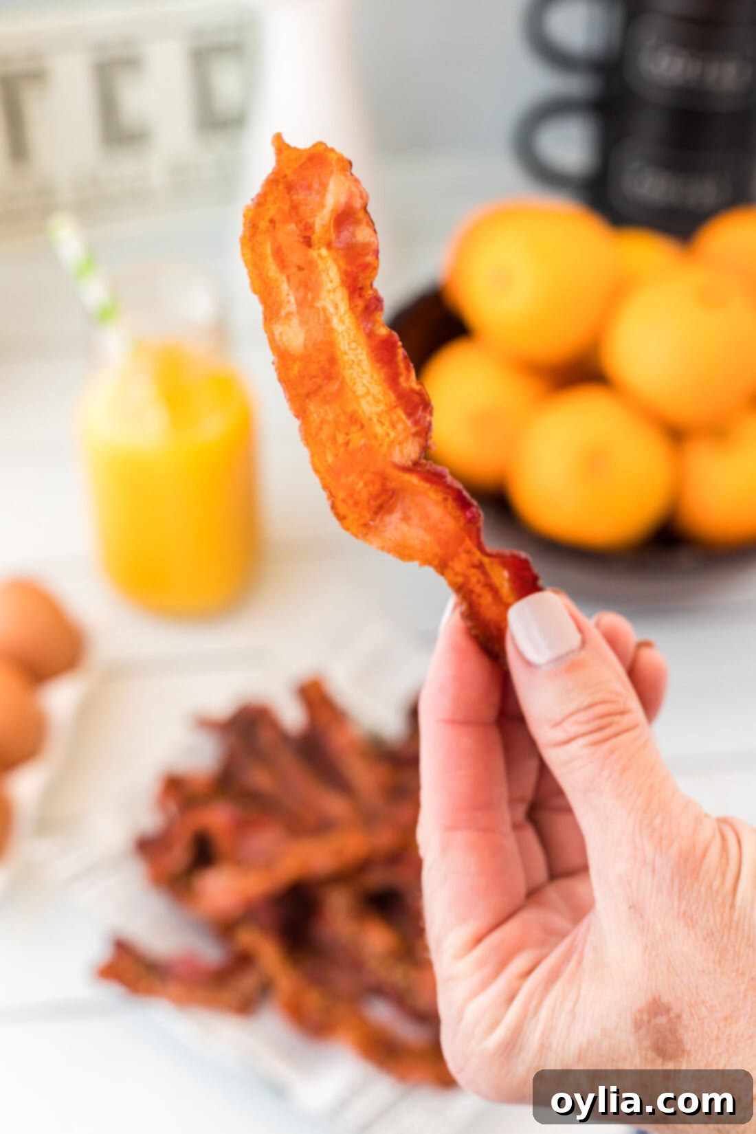 holding a piece of oven bacon
