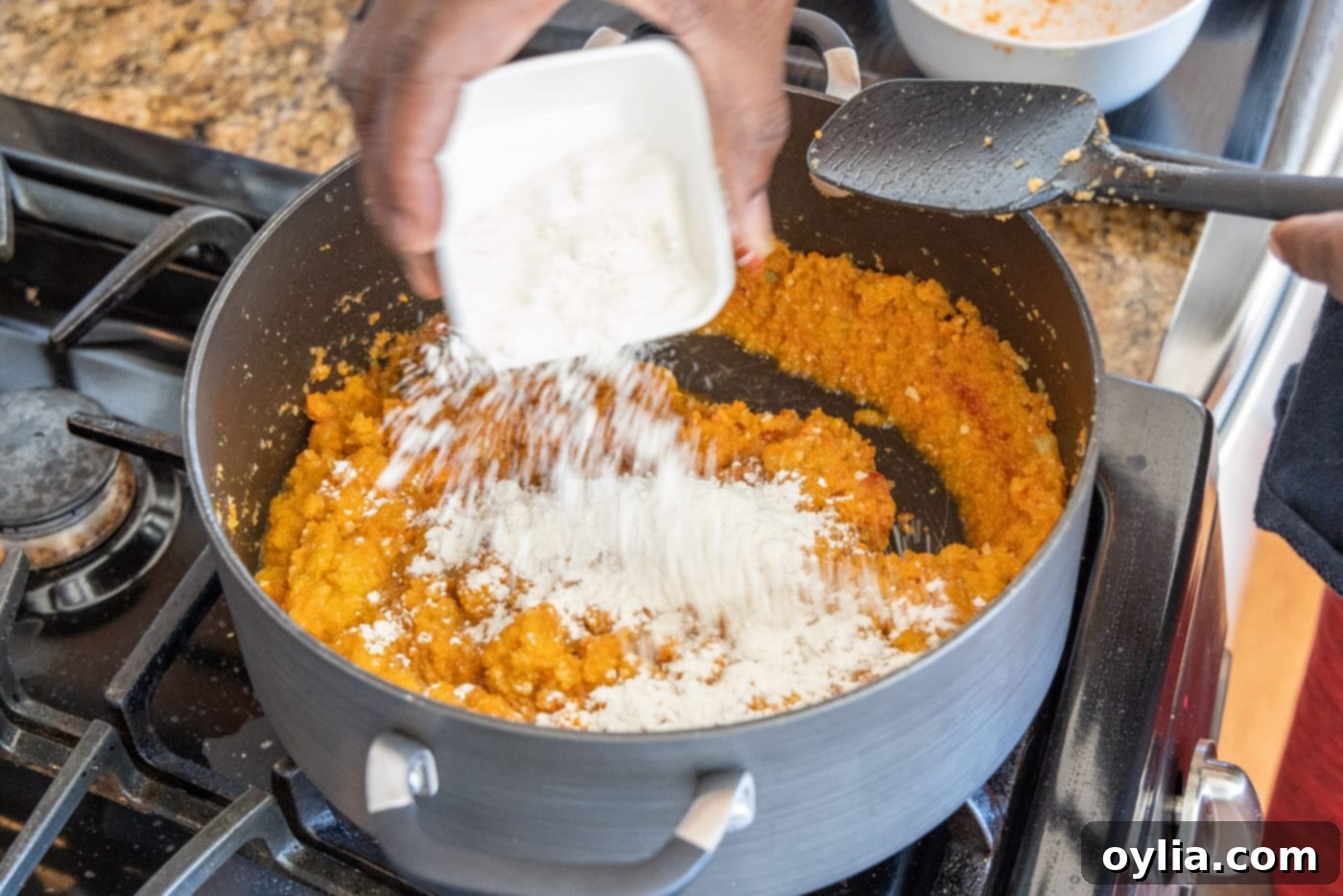 Velvet Sea Treasure 7 sprinkling all-purpose flour over the lobster bisque mixture in a Dutch oven, creating a roux