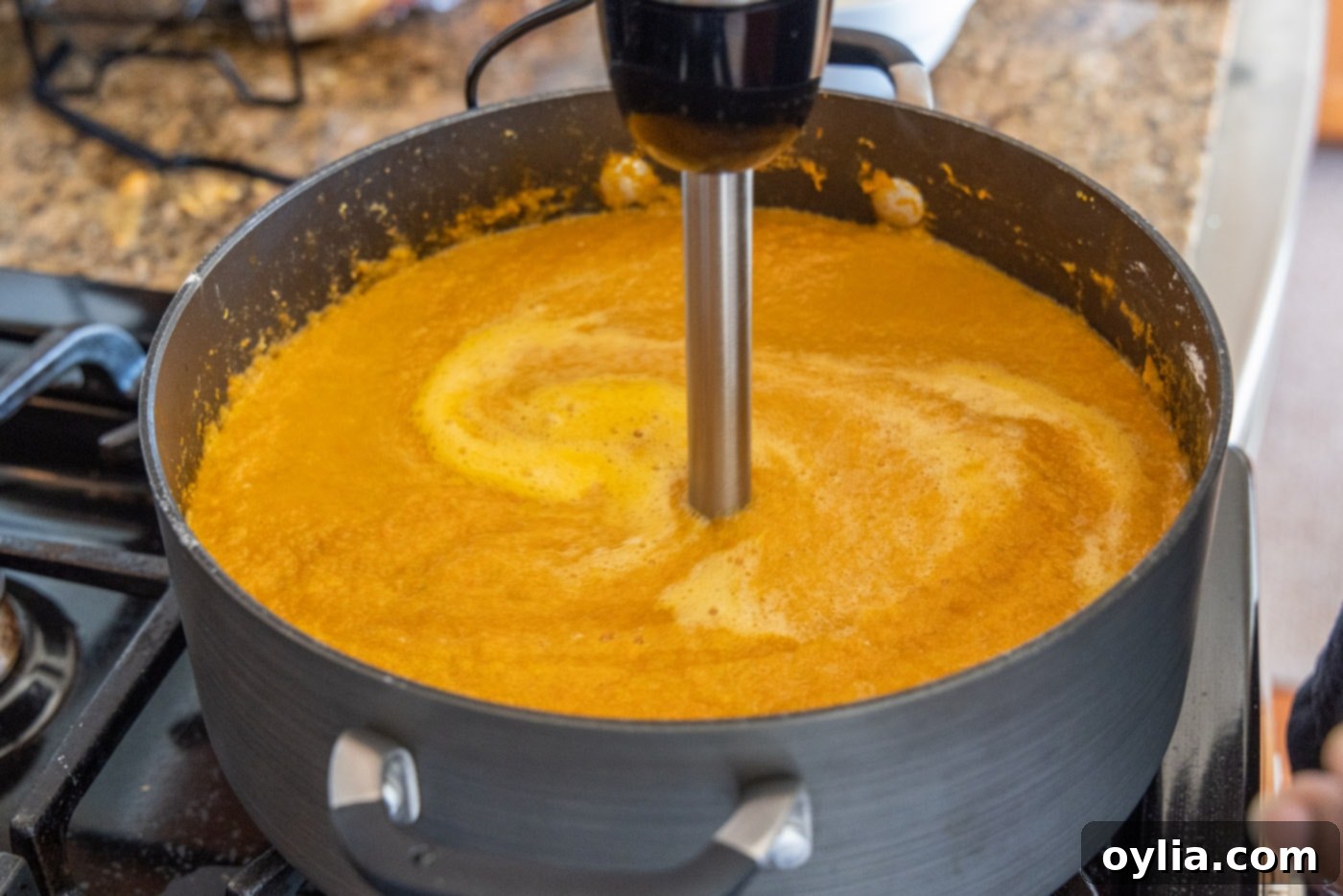 Velvet Sea Treasure 10 blending heavy cream into the lobster soup with an immersion blender for a smooth texture