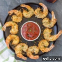 Air Fryer Coconut Shrimp on black plate with dipping sauce