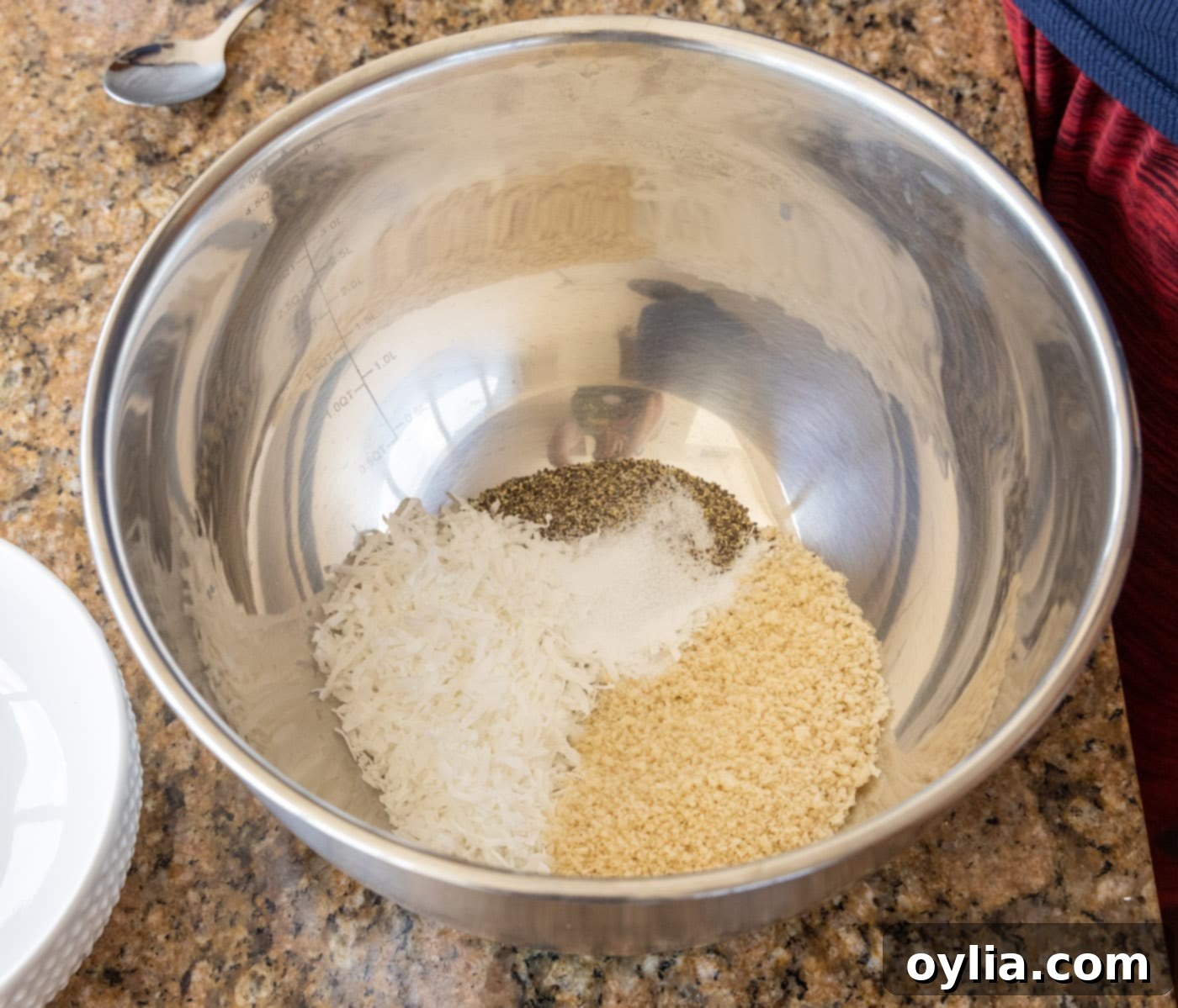 A large mixing bowl containing a mixture of breadcrumbs, coconut flakes, and seasonings, ready for shrimp coating.