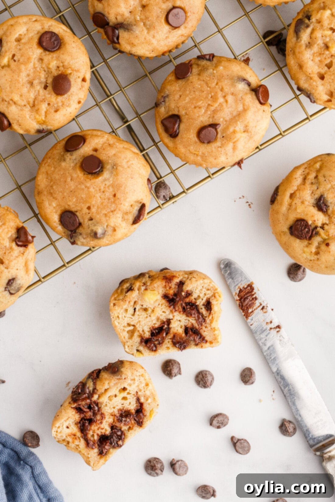 Chocolate Chip Banana Muffins on a wire rack with one cut open