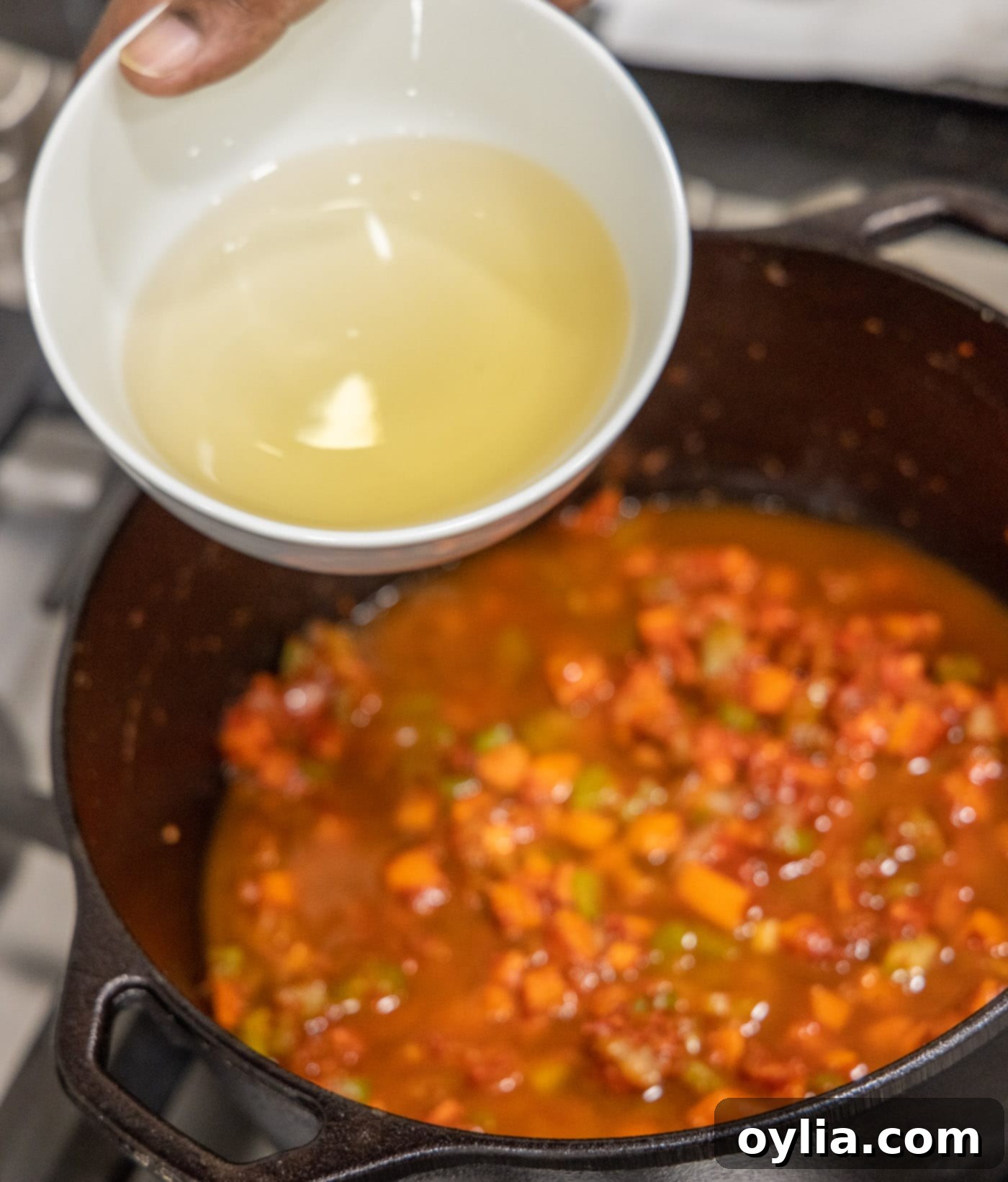 Adding dry white wine to the veal osso buco in the Dutch oven for depth of flavor