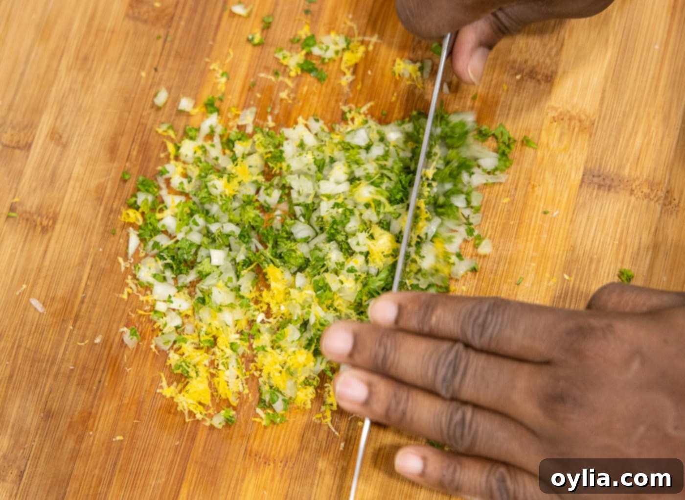 Freshly prepared gremolata, a vibrant mix of parsley, onion, and lemon zest, on a cutting board