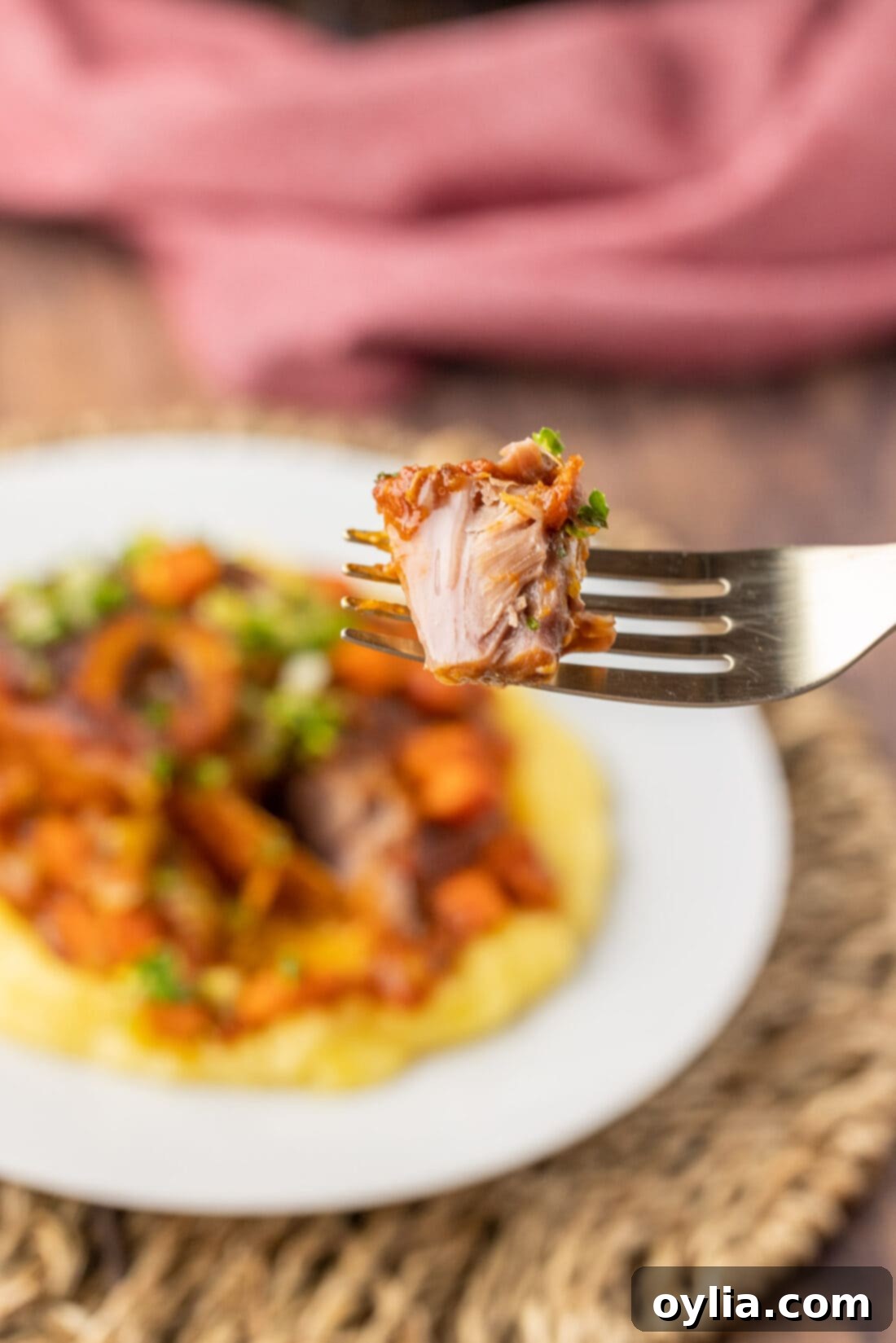 Close-up of a fork lifting a piece of tender Veal Osso Bucco, highlighting the rich sauce