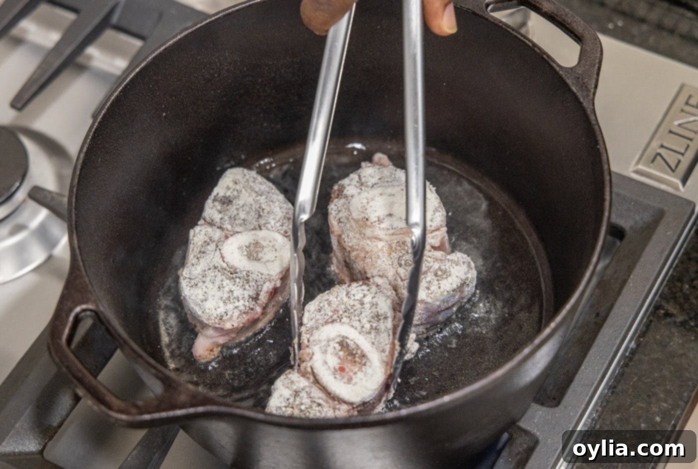 Searing veal shanks in a Dutch oven to develop a flavorful crust