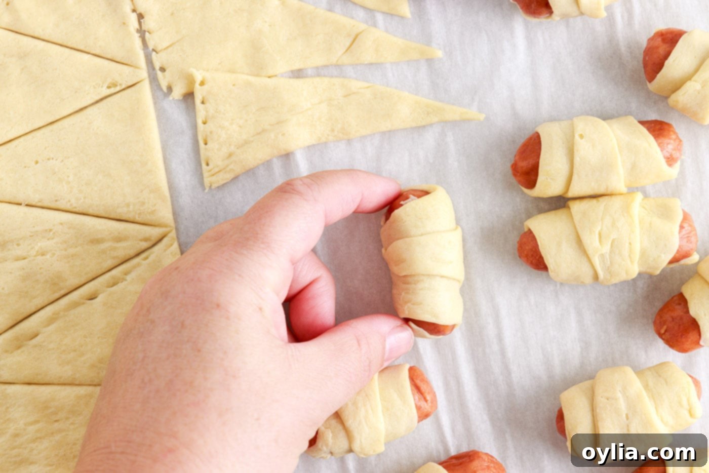 mini crescent dogs arranged on a parchment-lined baking sheet