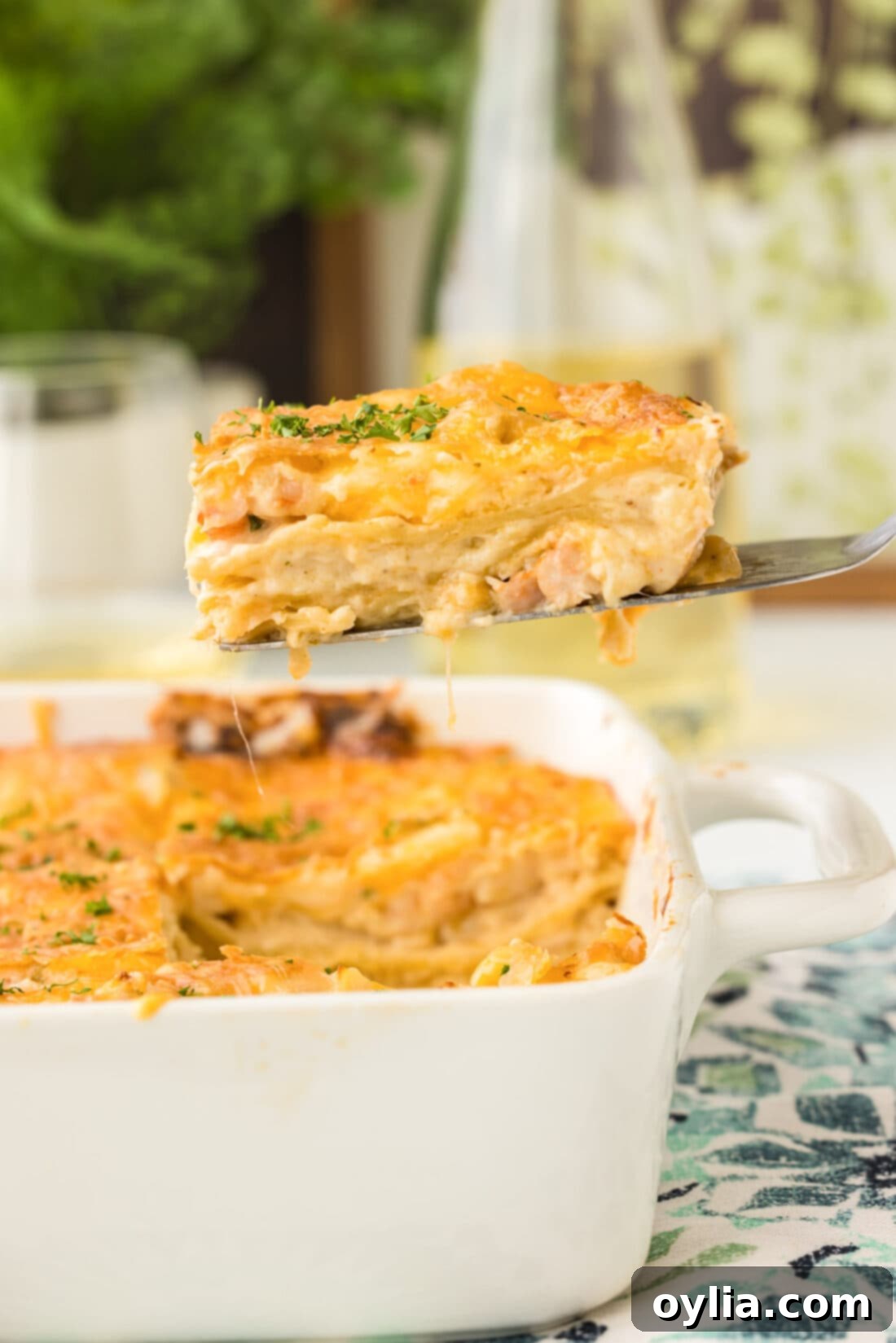 Lifting a golden-brown slice of creamy seafood lasagna, showcasing layers of pasta, sauce, and seafood