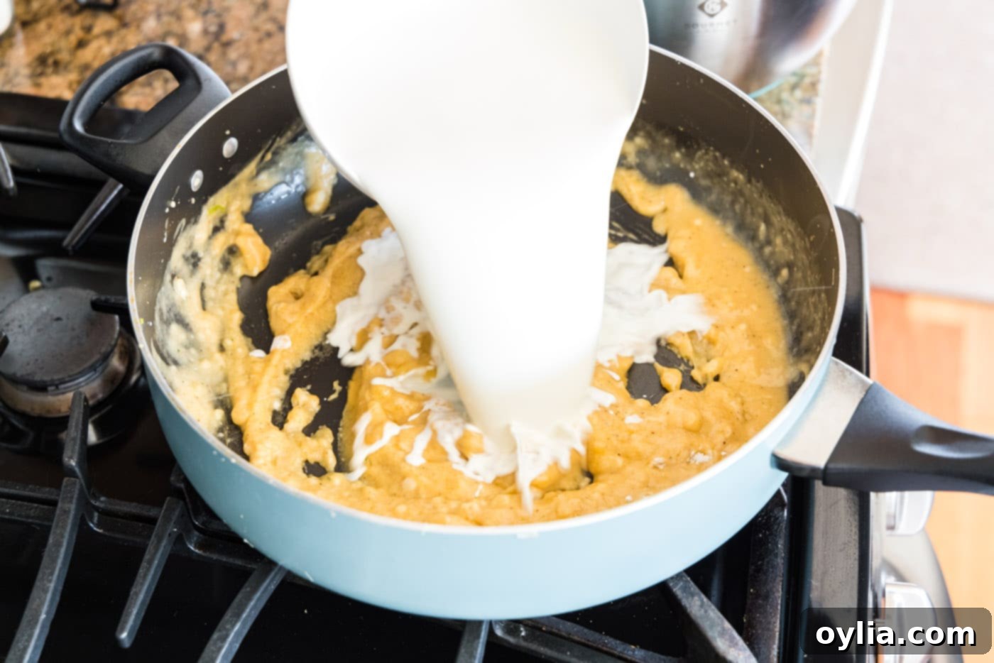 Pouring half and half into the skillet to create a creamy sauce
