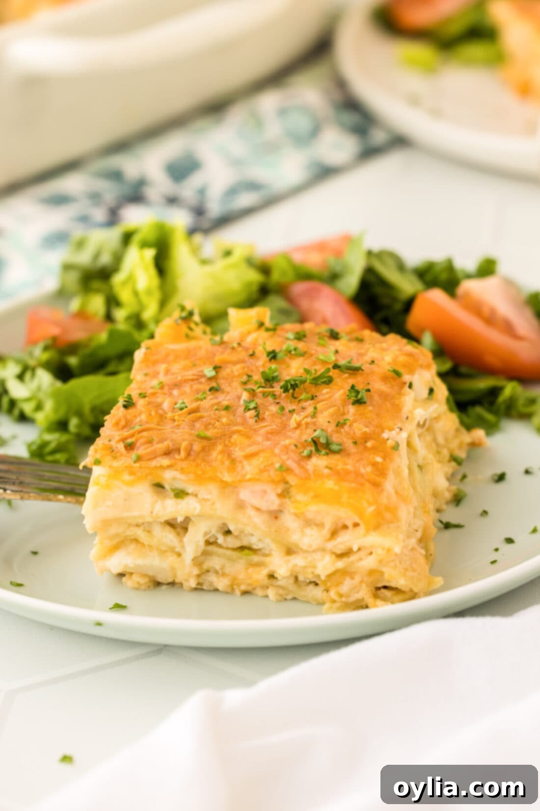 A perfect slice of seafood lasagna presented on a white plate, showcasing the creamy layers and golden cheese