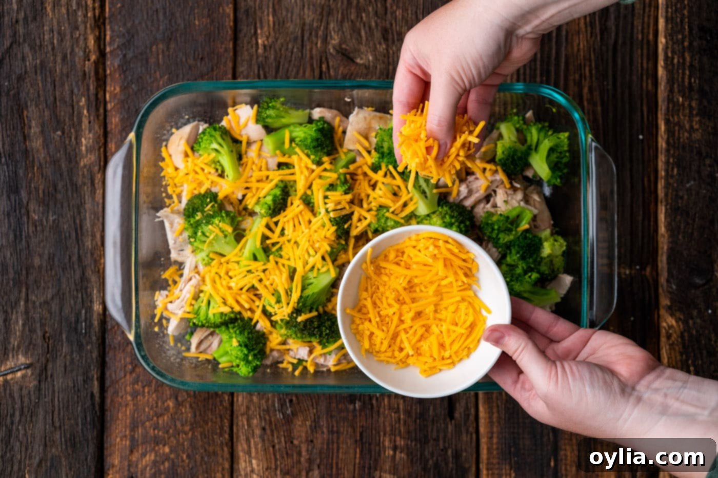 sprinkling cheddar cheese on top of broccoli and cheddar
