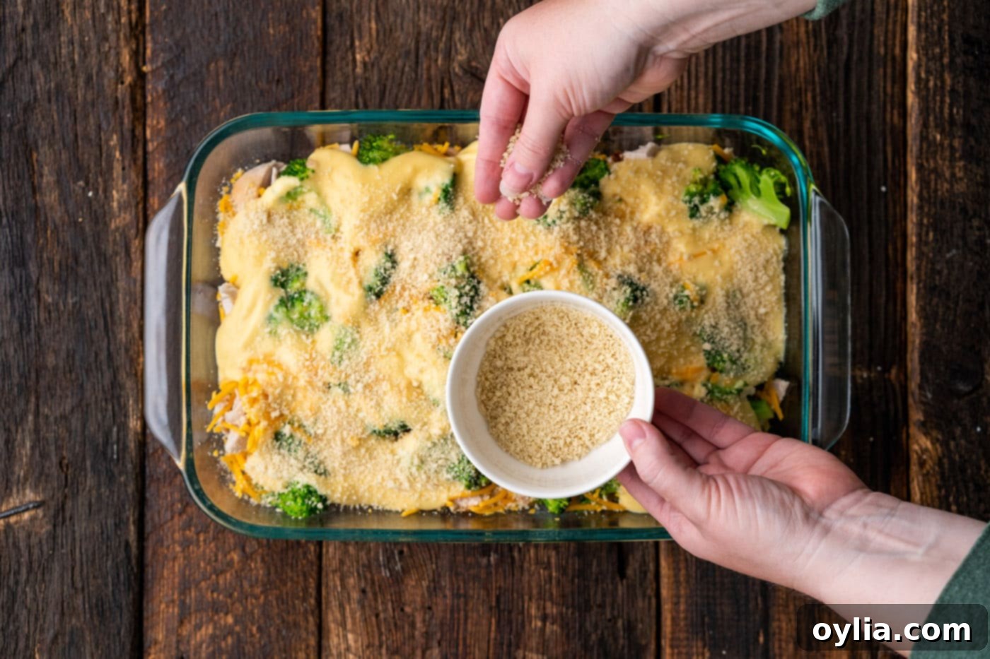 sprinkling breadcrumbs over chicken divan casserole