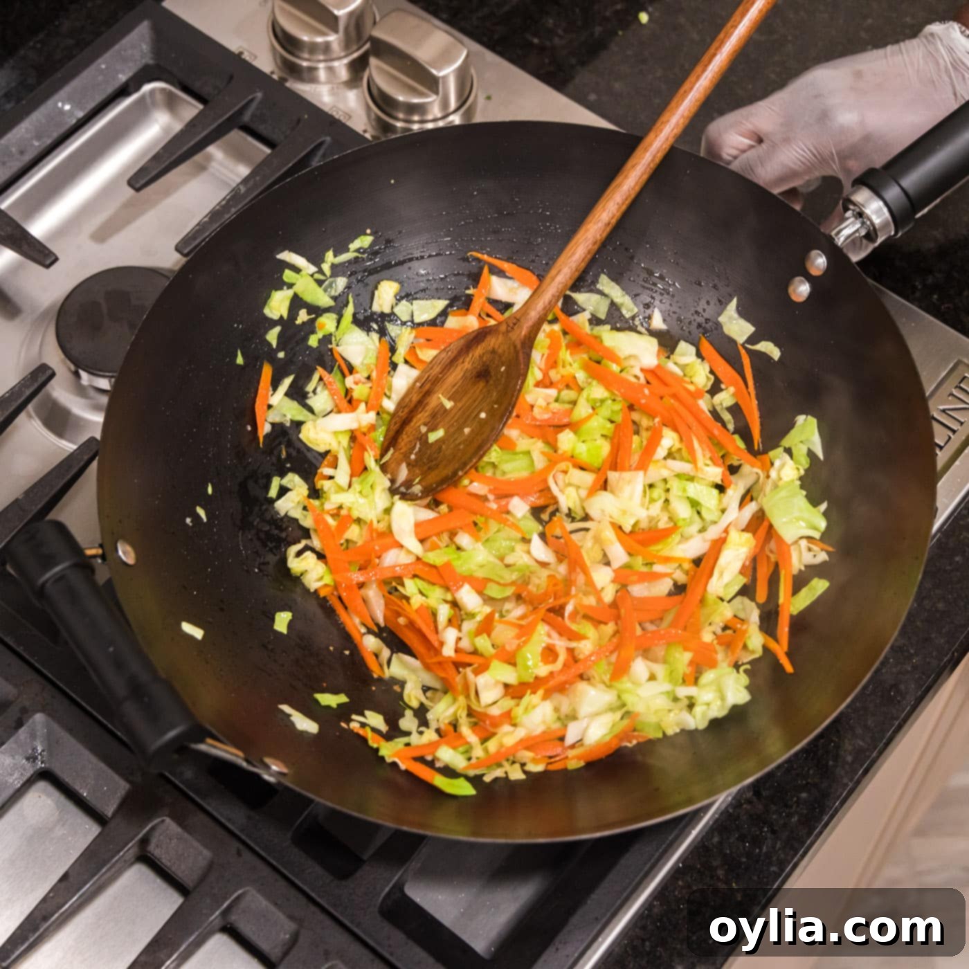 mixing chow mein vegetables in a wok