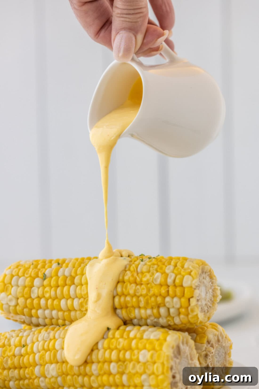 Velvety Hollandaise 8 pouring Hollandaise Sauce on corn