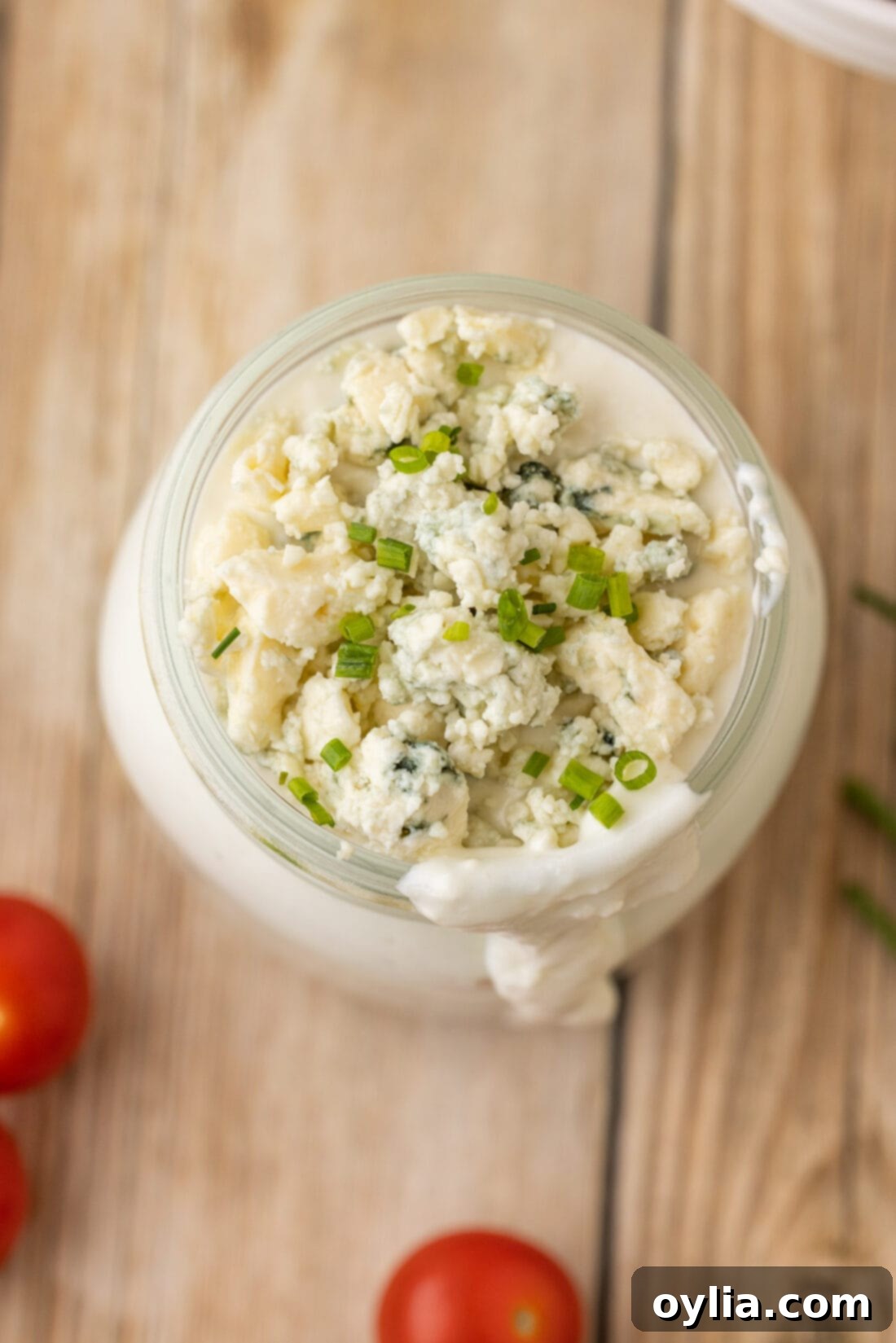 Overhead view of homemade blue cheese dressing in a glass jar, ready for serving.