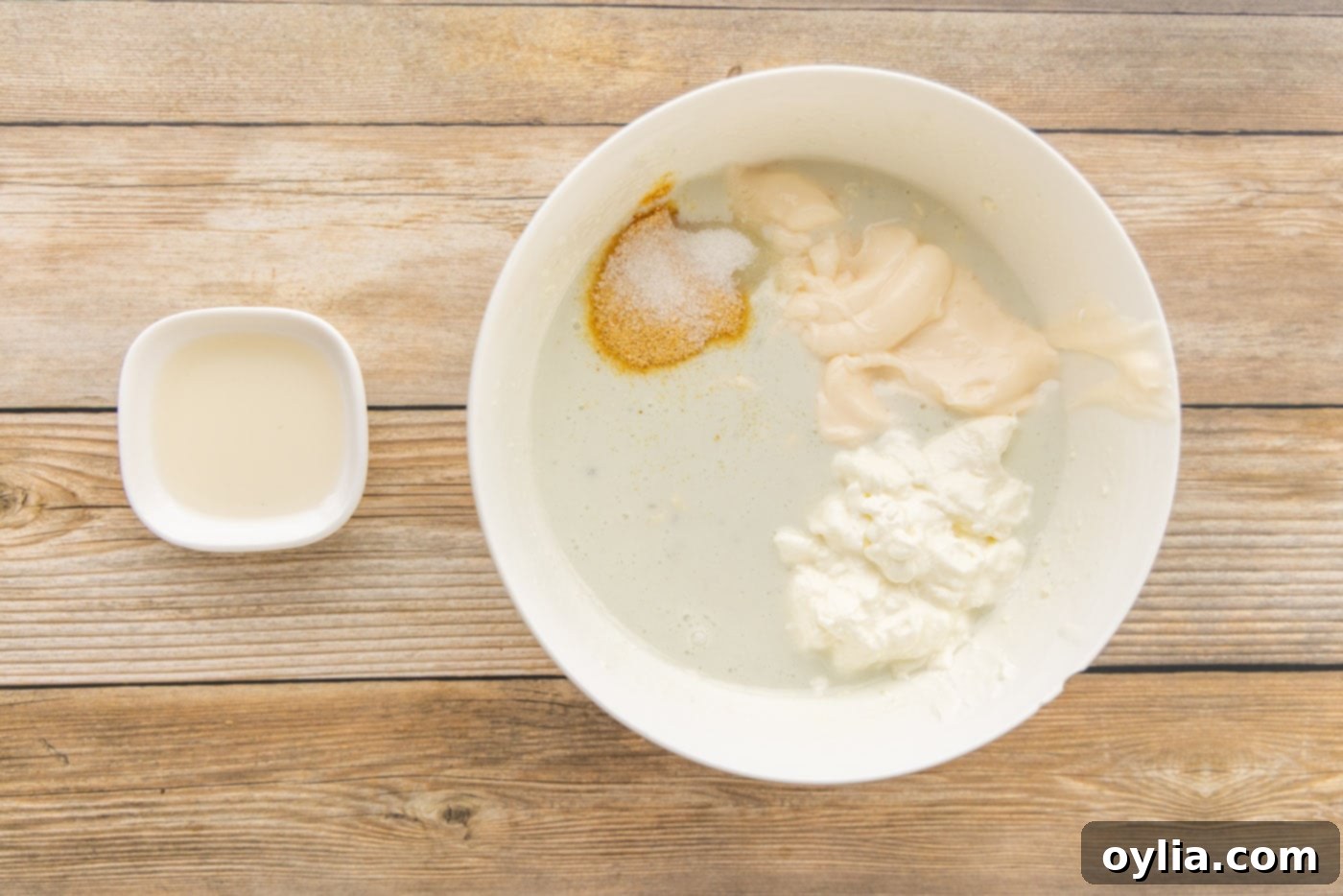 Mayonnaise, sour cream, and various seasonings being added to the blue cheese and buttermilk mixture.