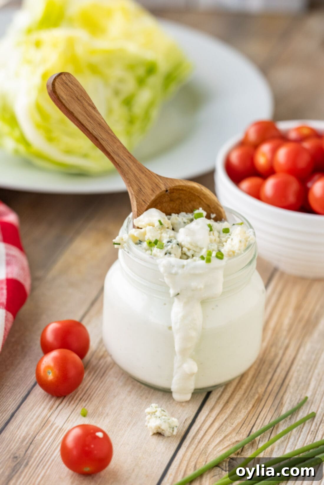 Close-up of creamy blue cheese dressing in a jar with a spoon, showing its appealing texture.