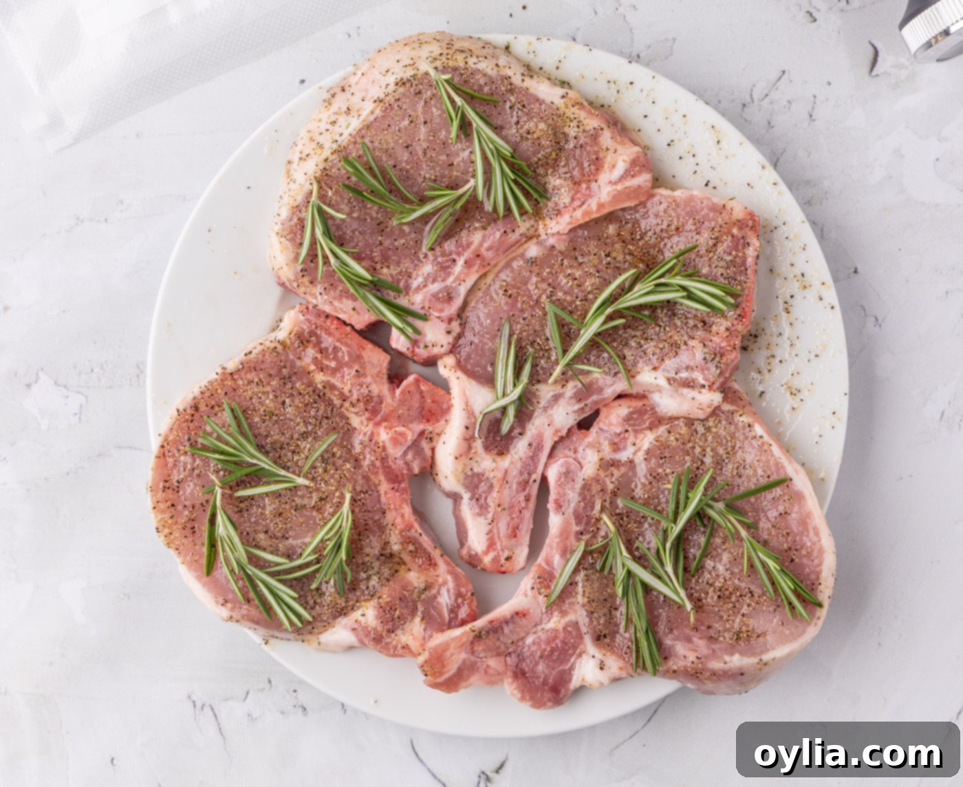 pork chops with rosemary sprigs coated in a wet rub