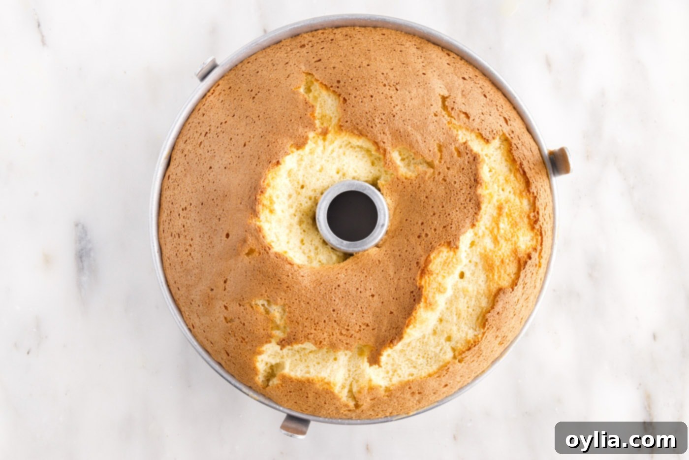 Freshly baked chiffon cake cooling in a tube pan