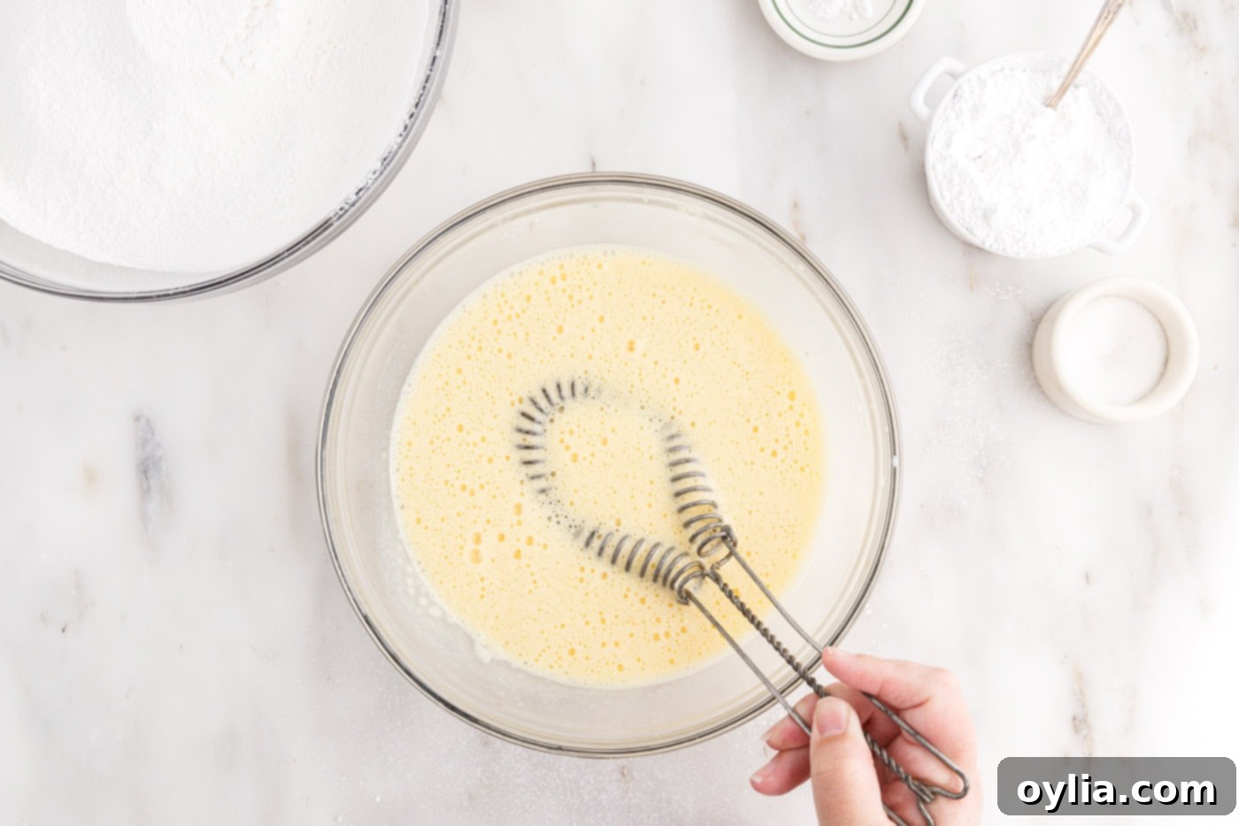 Close-up of the smooth, whisked egg yolk mixture in a bowl