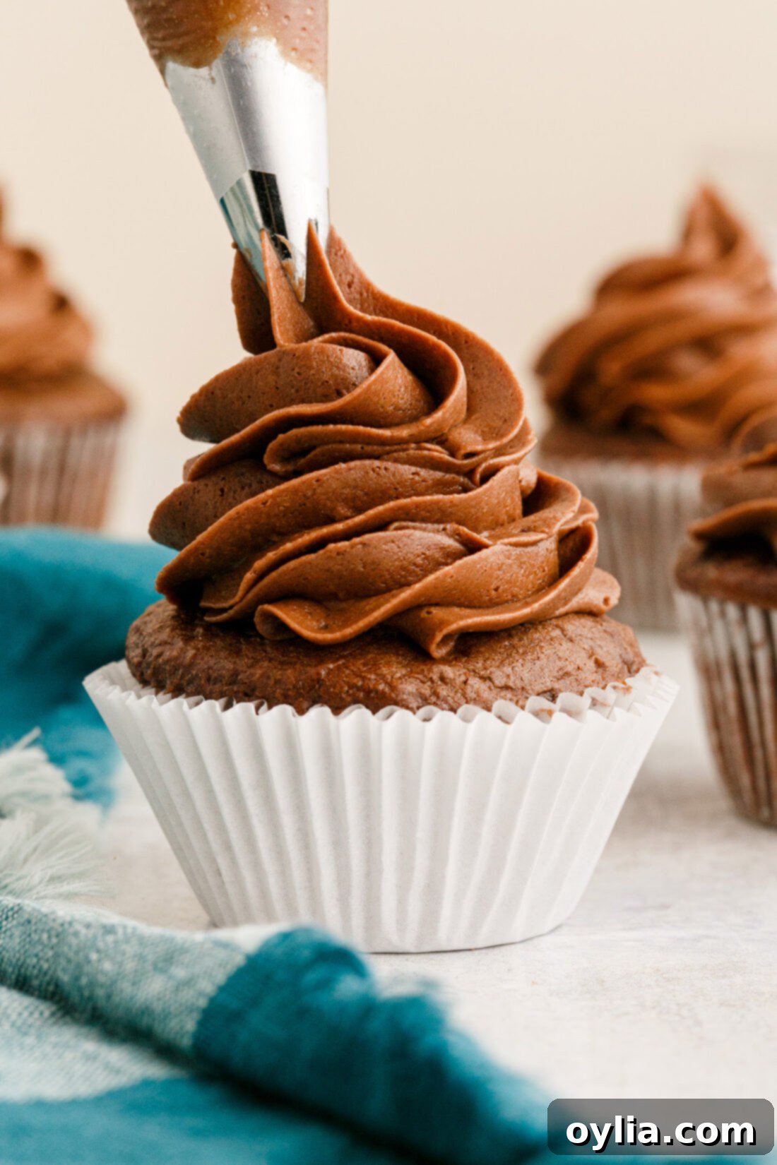piping Chocolate Buttercream Frosting onto a cupcake