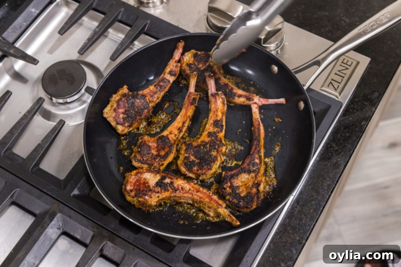 Flipping lamb chops in a skillet to sear the other side