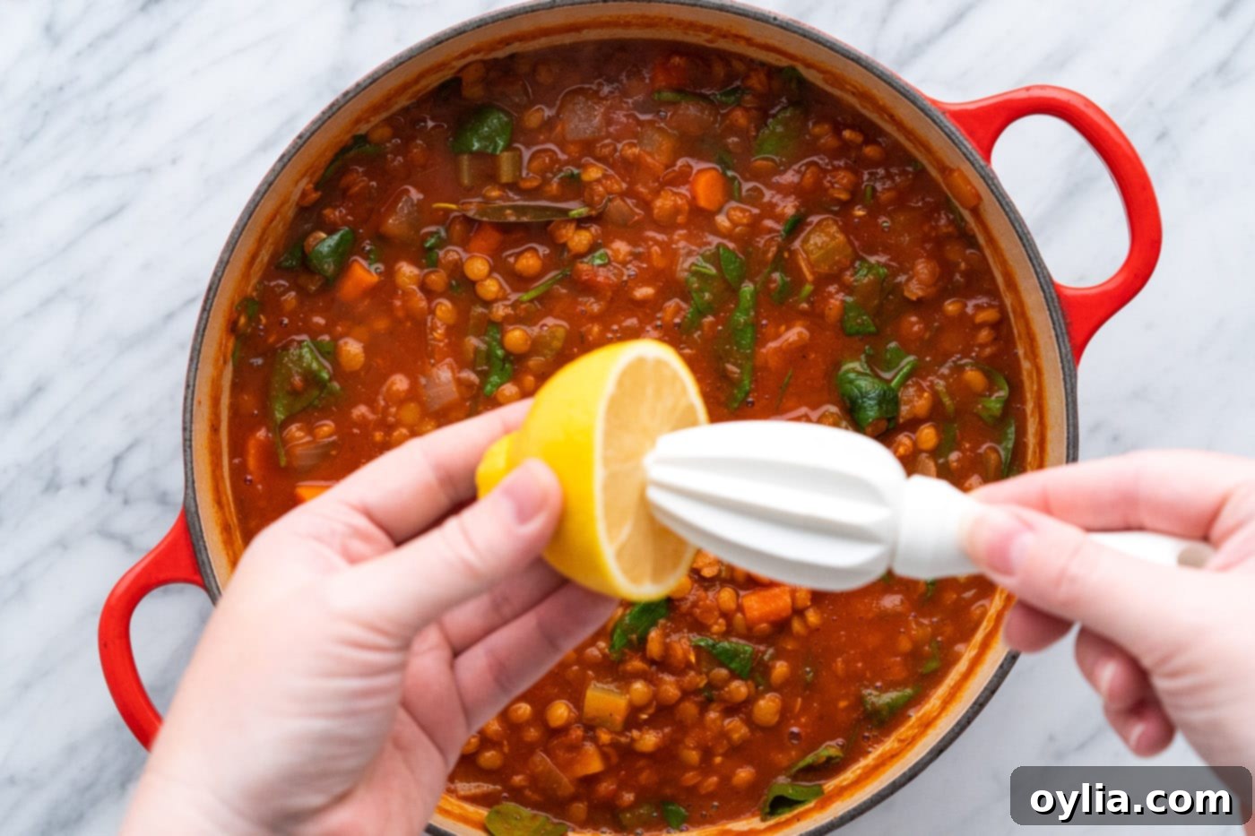 squeezing fresh lemon juice over lentil soup