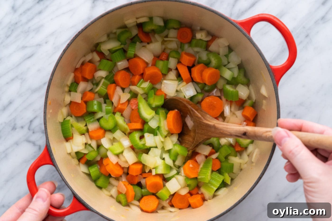 sauteeing onion, celery, and carrot with oil in a pot