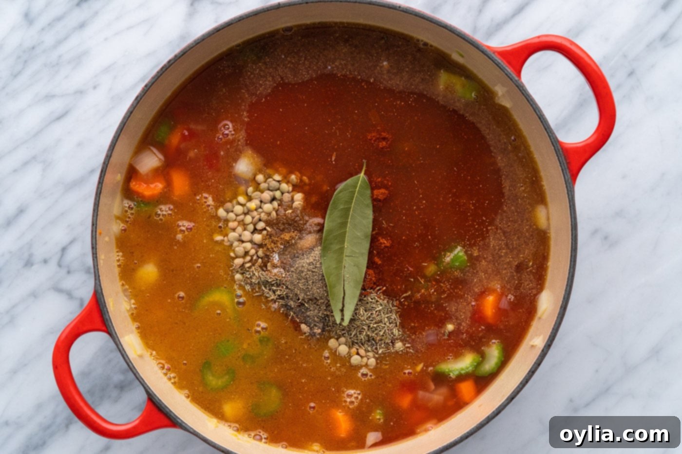 seasonings on top of lentil soup in a pot
