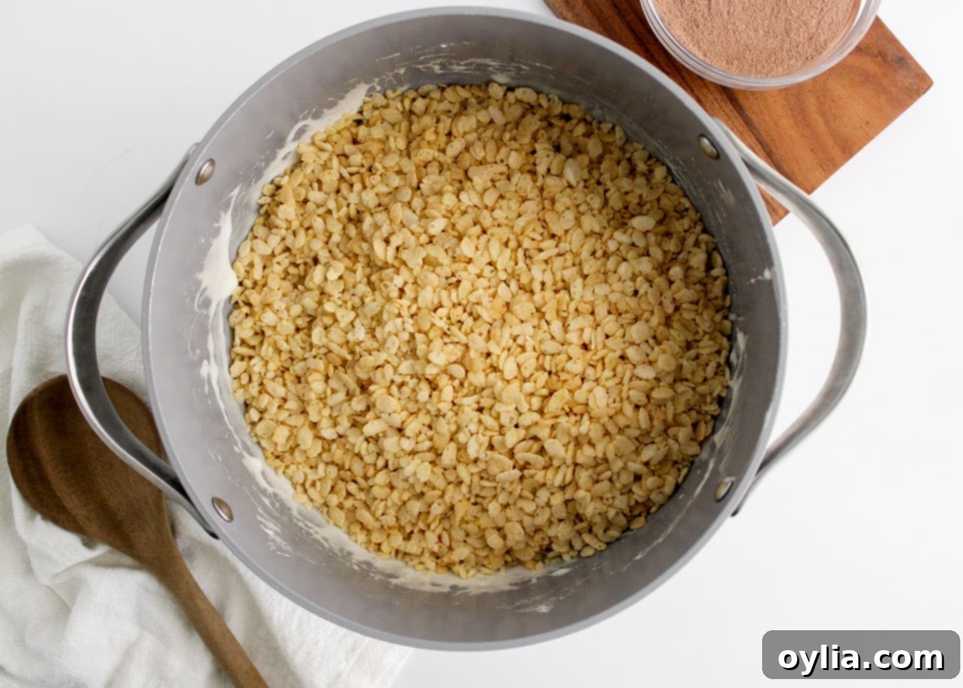 adding rice krispie cereal to marshmallow mixture
